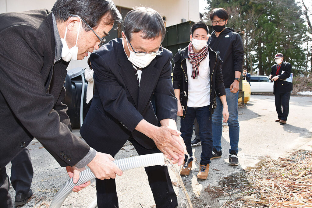 酵素の力で浄化された水で手を洗う参加者